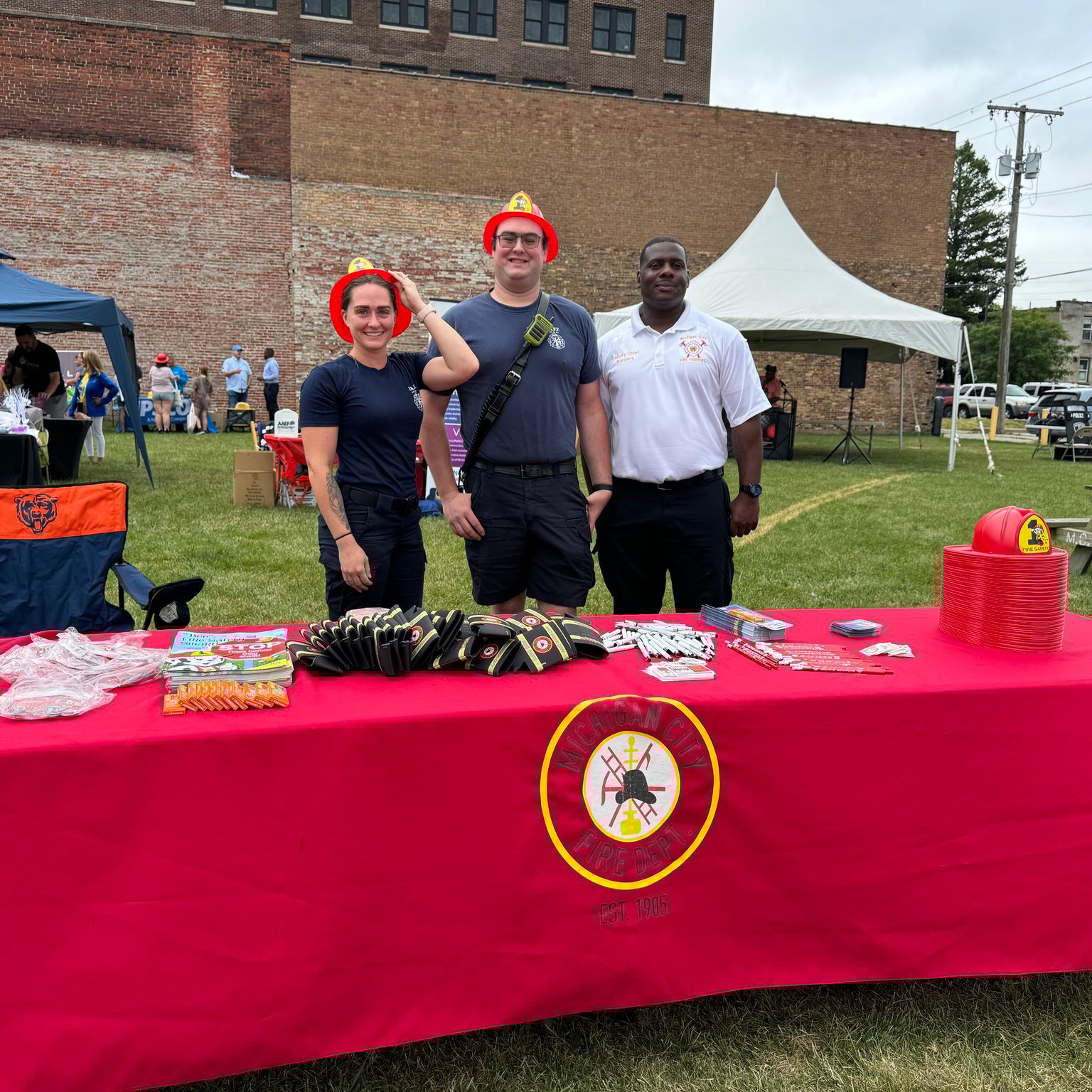 480807390_946293121017579_3684481395060715827_n-scaled Michigan City Fire Department members at a community outreach event table with fire safety giveaways and educational materials