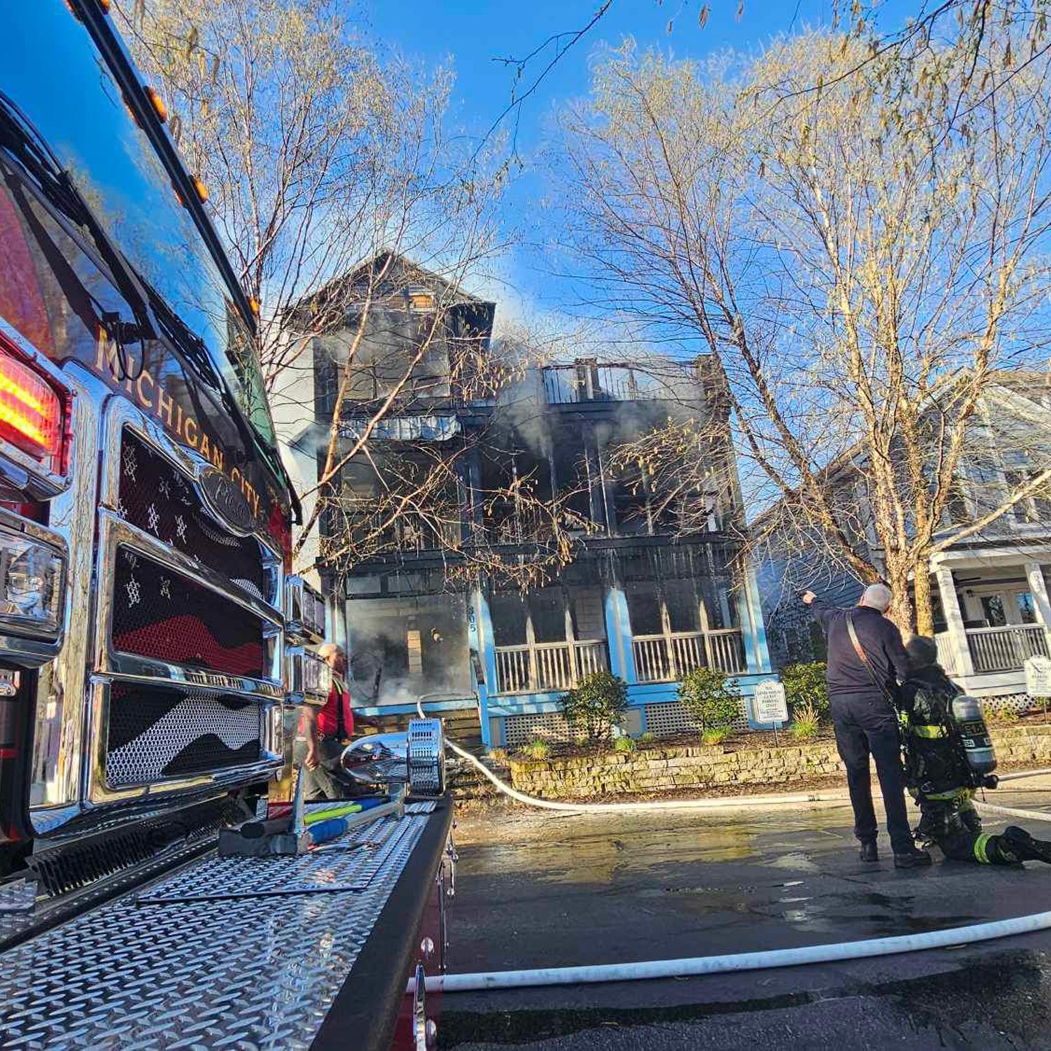 IMG_3570-scaled firefighters responding to a house fire with smoke visible and a fire engine in the foreground